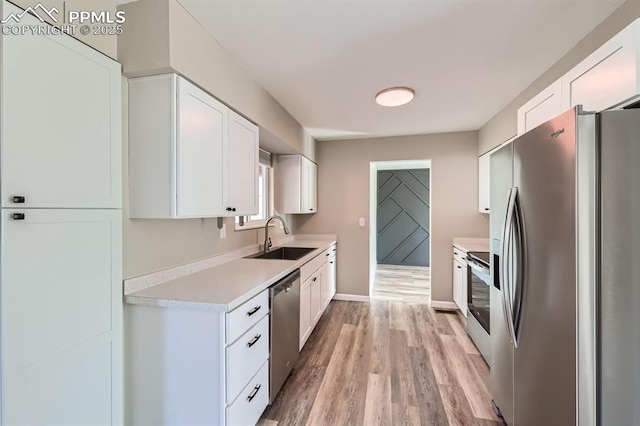 kitchen with white cabinetry, sink, light hardwood / wood-style flooring, and stainless steel appliances