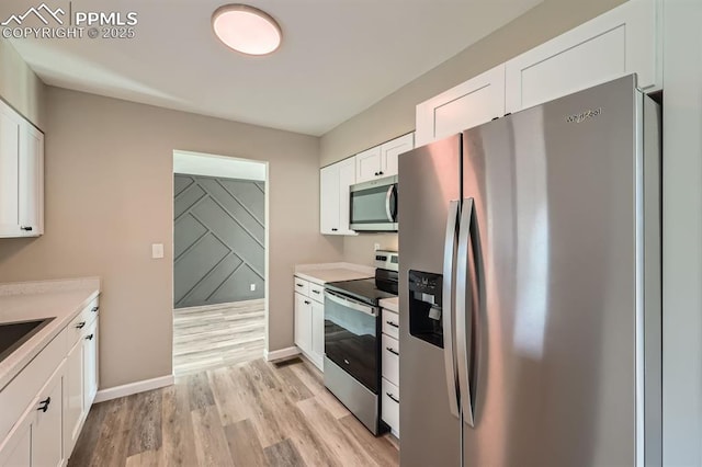 kitchen with light hardwood / wood-style floors, white cabinets, and appliances with stainless steel finishes