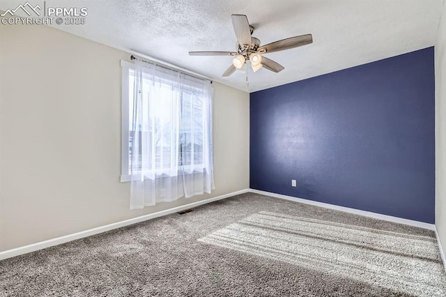 carpeted spare room with ceiling fan and a textured ceiling