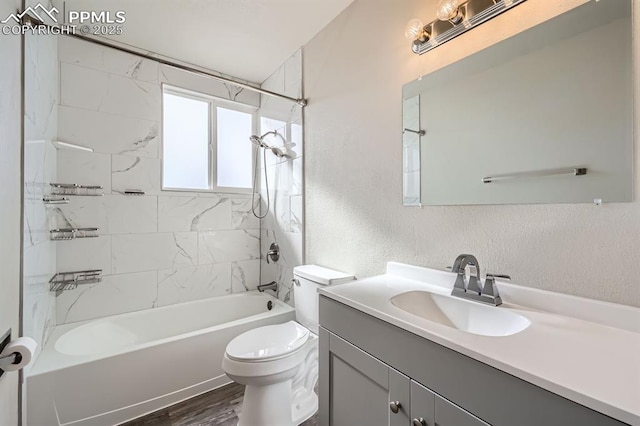 full bathroom with tiled shower / bath, vanity, toilet, and wood-type flooring