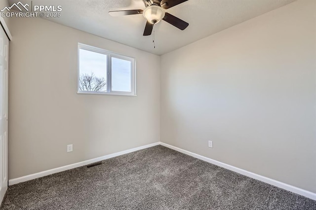 empty room featuring ceiling fan and carpet