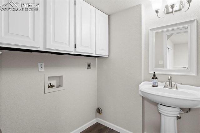 clothes washing area featuring cabinets, electric dryer hookup, dark hardwood / wood-style floors, and washer hookup