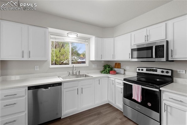 kitchen featuring stainless steel appliances, white cabinetry, sink, and dark wood-type flooring