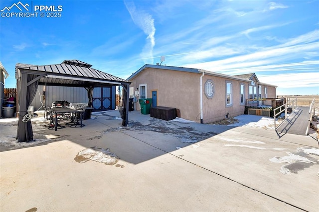 view of side of home featuring a gazebo and a patio area