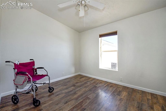 sitting room with dark wood-type flooring and ceiling fan