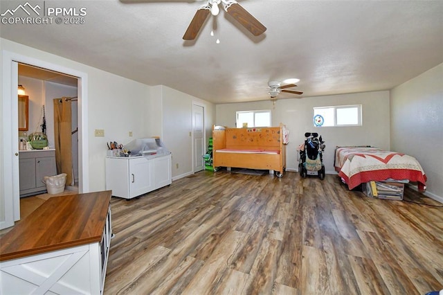 bedroom with ensuite bath, dark wood-type flooring, and ceiling fan