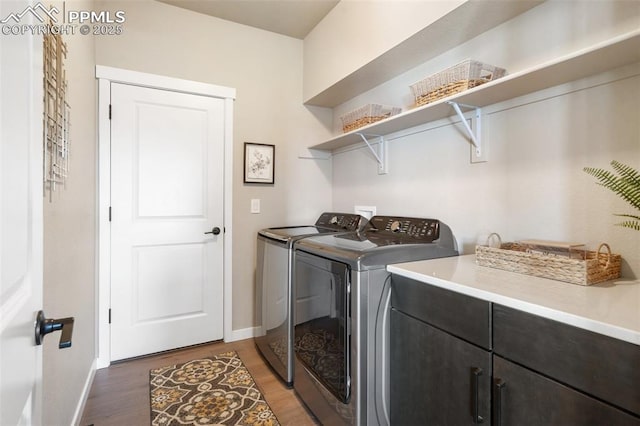 clothes washing area featuring dark hardwood / wood-style flooring and washer and clothes dryer