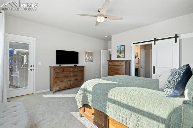 bedroom featuring ceiling fan, a barn door, and light carpet