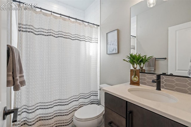 bathroom with tasteful backsplash, vanity, and toilet