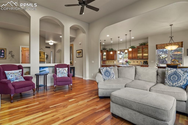 living room with light hardwood / wood-style floors and ceiling fan