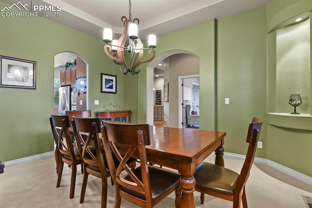 carpeted dining space with a chandelier