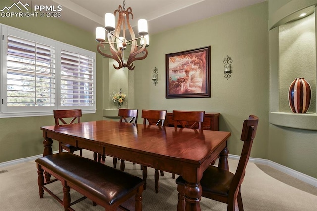 carpeted dining area featuring a notable chandelier