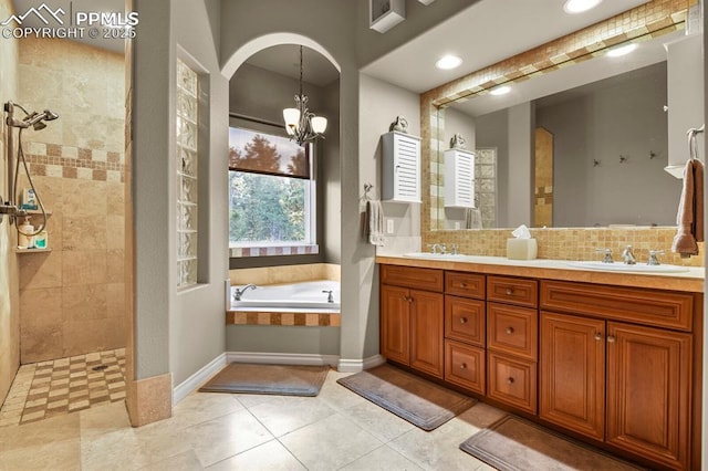 bathroom featuring tile patterned floors, an inviting chandelier, vanity, backsplash, and separate shower and tub