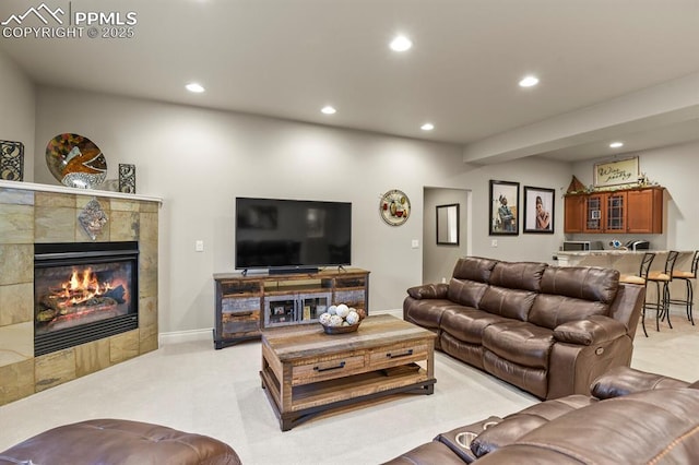 carpeted living room featuring a tiled fireplace