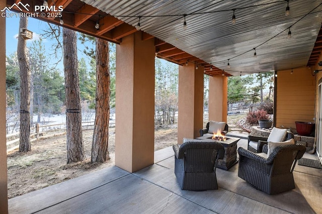 view of patio with an outdoor fire pit and a water view