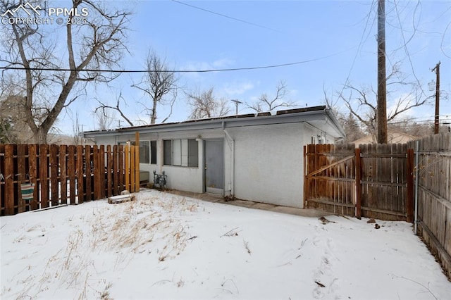 view of snow covered back of property