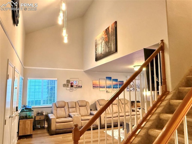 stairway featuring high vaulted ceiling and wood-type flooring