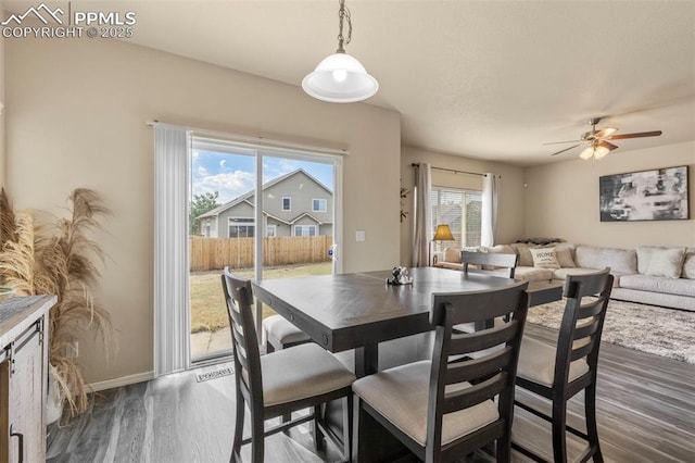 dining area with ceiling fan, plenty of natural light, and dark hardwood / wood-style floors