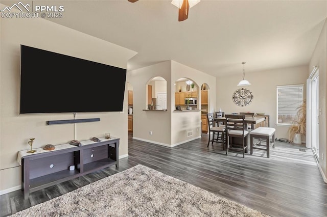 living room featuring ceiling fan and dark hardwood / wood-style floors