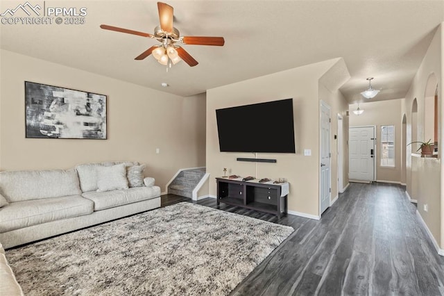 living room featuring ceiling fan and dark hardwood / wood-style flooring