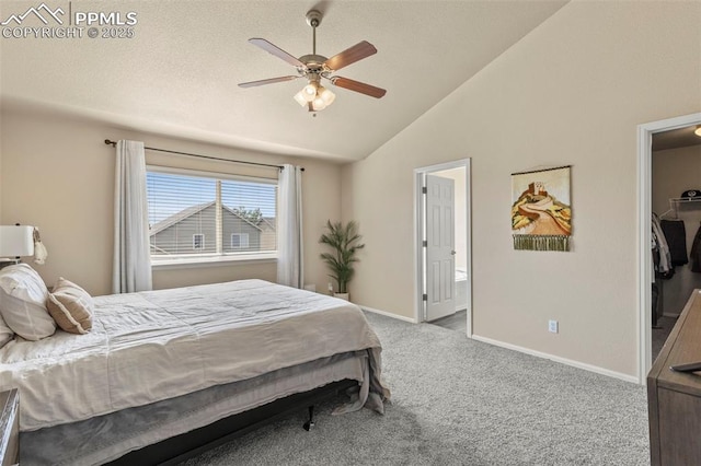 carpeted bedroom featuring a closet, vaulted ceiling, ceiling fan, and a walk in closet