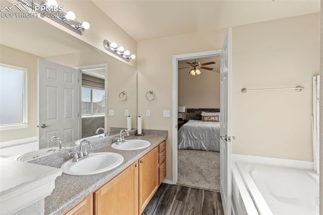 bathroom featuring hardwood / wood-style flooring, vanity, and a bath