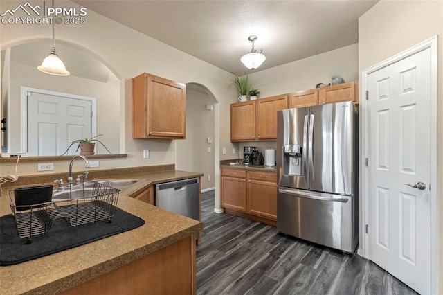 kitchen featuring pendant lighting, dark hardwood / wood-style floors, appliances with stainless steel finishes, and sink