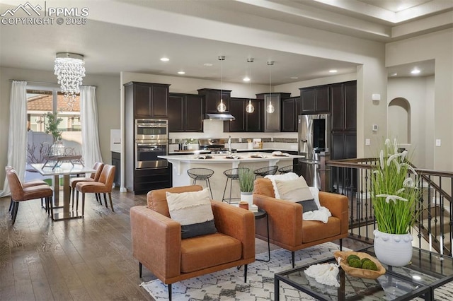 living room featuring an inviting chandelier and dark hardwood / wood-style floors