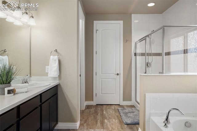 bathroom with vanity, shower with separate bathtub, and hardwood / wood-style floors