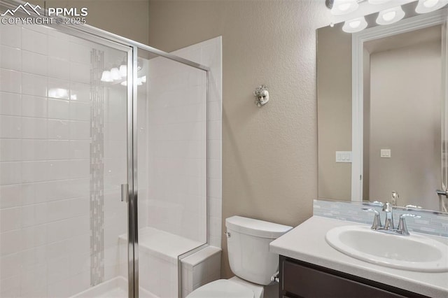 bathroom featuring an enclosed shower, vanity, and toilet