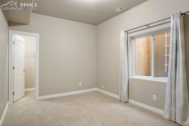 unfurnished room featuring light carpet