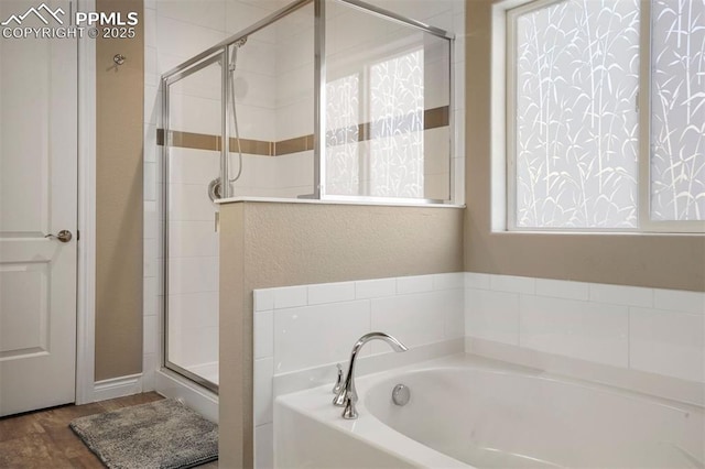 bathroom featuring independent shower and bath and wood-type flooring