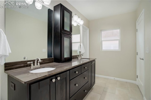 full bathroom featuring double vanity, a sink, and baseboards