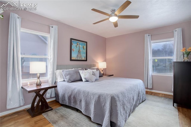 bedroom featuring light wood-style floors, ceiling fan, and baseboards