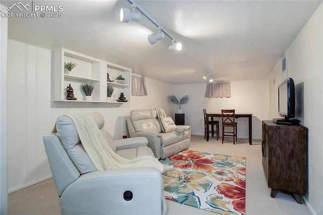 living room with carpet floors, visible vents, and track lighting