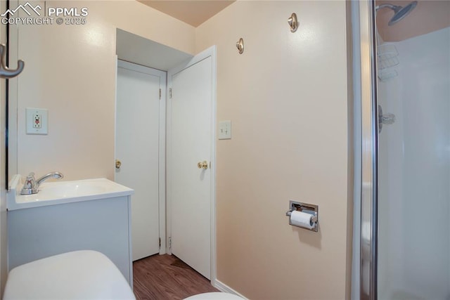 full bathroom featuring a shower, vanity, toilet, and wood finished floors