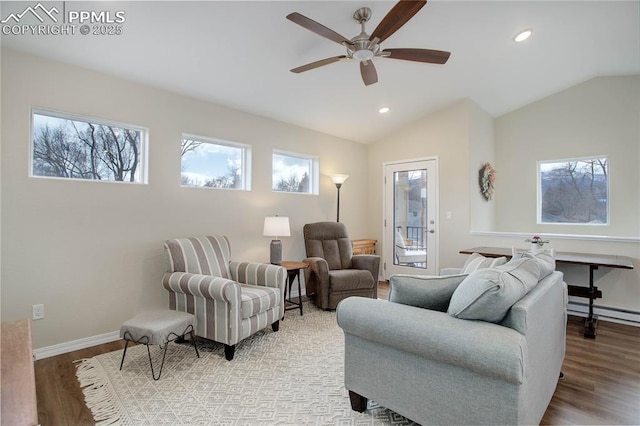 living area with lofted ceiling, wood finished floors, and a wealth of natural light