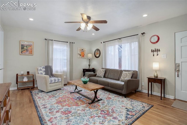 living area featuring light wood-type flooring, a wealth of natural light, and baseboards