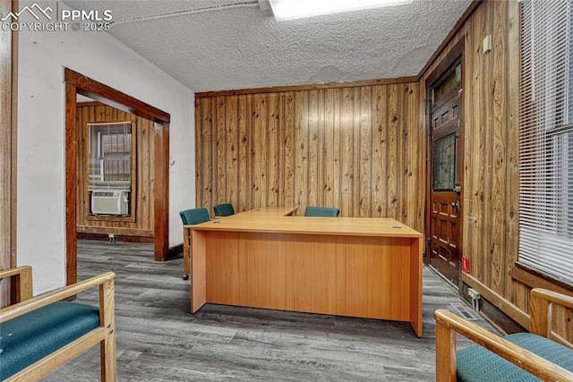 office featuring cooling unit, wooden walls, dark hardwood / wood-style flooring, and a textured ceiling