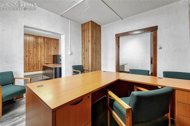 office area with light hardwood / wood-style floors and a textured ceiling