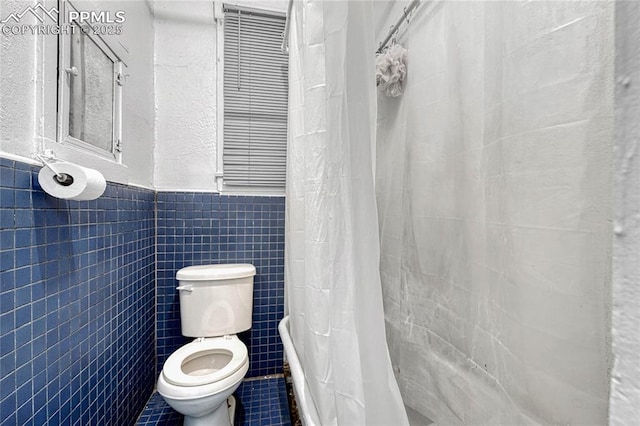 bathroom featuring tile walls and toilet