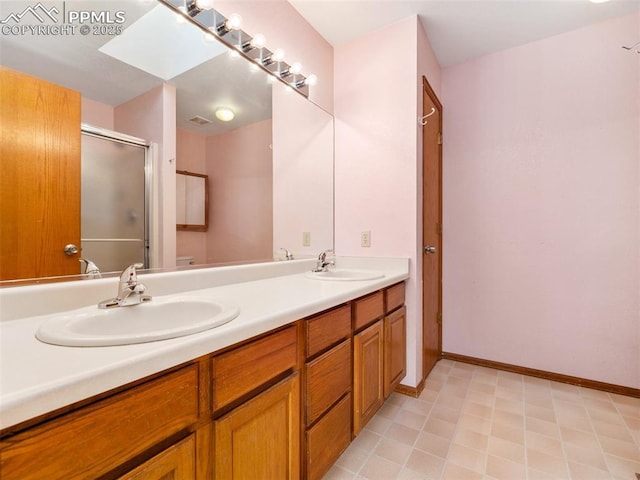 bathroom with an enclosed shower, vanity, and a skylight