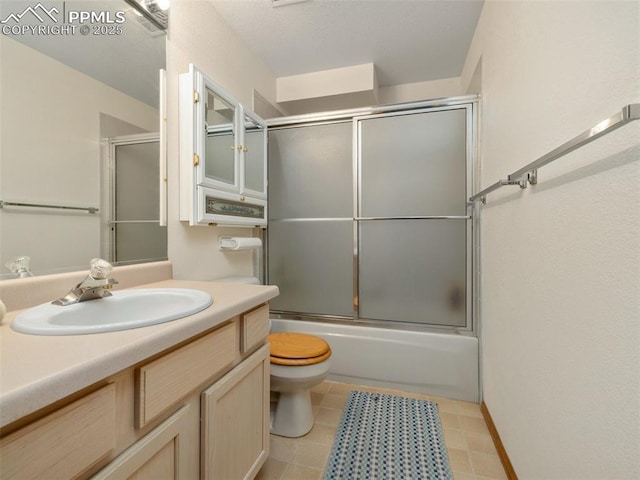 full bathroom featuring vanity, combined bath / shower with glass door, and toilet