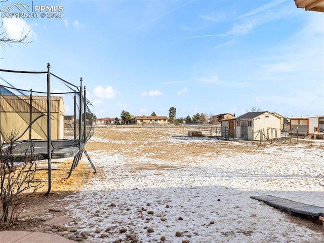 view of yard with a trampoline and a shed