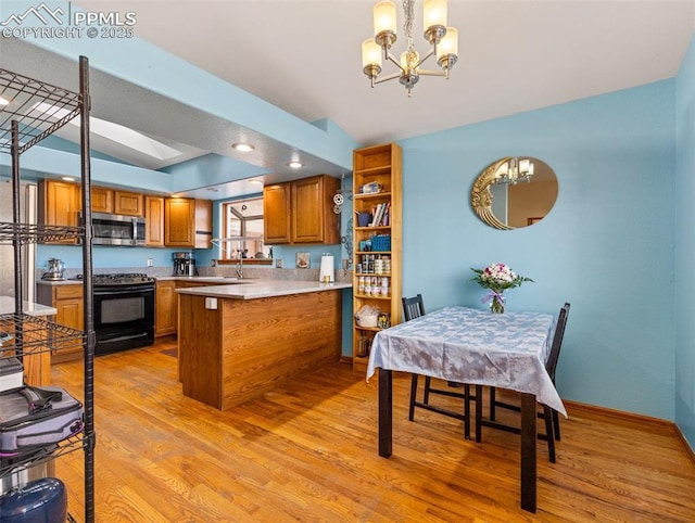 kitchen featuring a chandelier, hanging light fixtures, kitchen peninsula, gas stove, and light hardwood / wood-style flooring