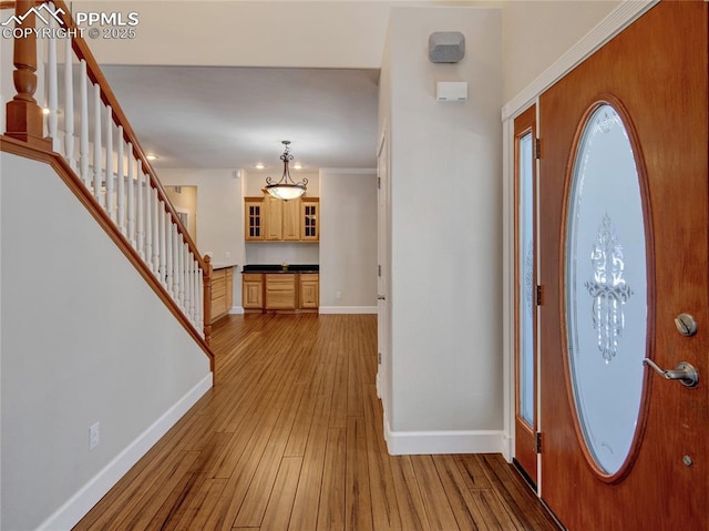 foyer featuring light wood-type flooring and ornamental molding