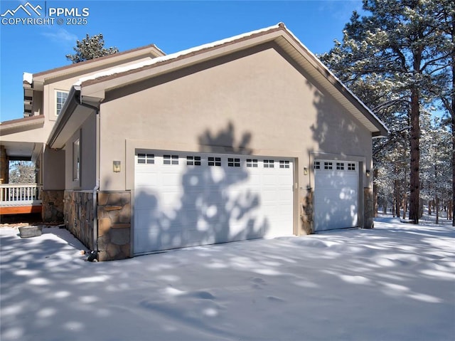 snow covered property with a garage