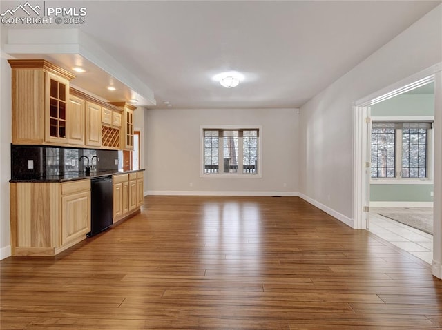 kitchen featuring light brown cabinetry, backsplash, black dishwasher, and hardwood / wood-style floors