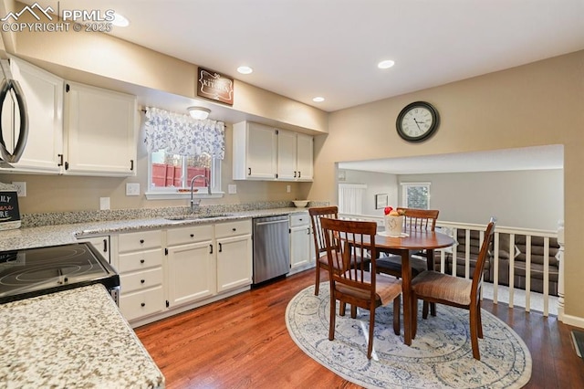 kitchen featuring white cabinetry, sink, wood-type flooring, and stainless steel dishwasher