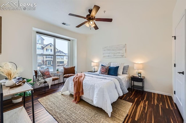 bedroom with dark hardwood / wood-style flooring and ceiling fan